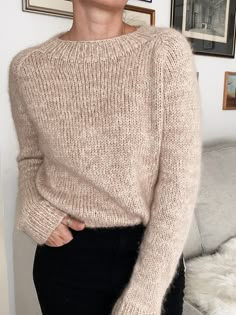 a woman standing in front of a couch with her hands on her hips