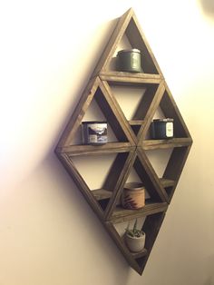 a wooden shelf with some candles on it and other items in front of the wall