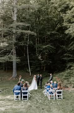 a bride and groom are getting married in the woods