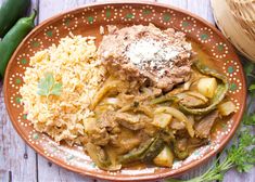 a plate with rice, meat and vegetables on it next to a basket of green beans