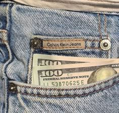 money sticking out of the back pocket of someone's jean pants that are rolled up