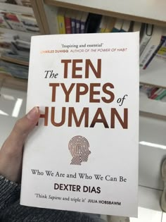 a person holding up a book about the types of human