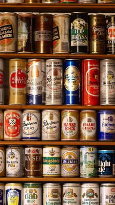 many different types of beer cans on a shelf