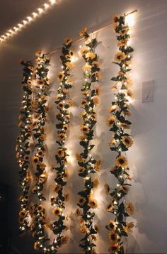 the sunflowers are hanging from the wall with lights on them and there is no image here to provide a caption for