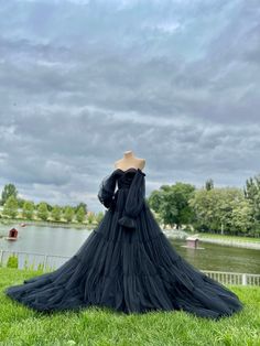 the back of a dress on display in front of a body of water