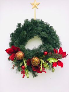 a christmas wreath with poinsettis and greenery