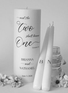 two white candles sitting next to each other