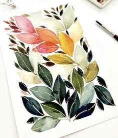 a watercolor painting of leaves on paper next to paintbrushes and paintsticks