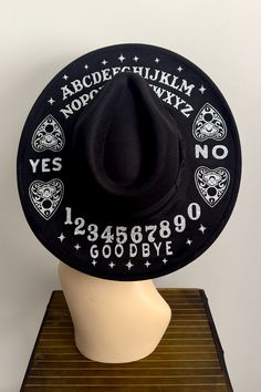 Bring your inner witch to life with our Spirit Board Wide Brim Hat! This black, wide brim hat features a glittery spirit board graphic, so you can show off your witchy vibes while keeping your style on-point. Perfect for protecting yourself from magical spells -- and from the elements! Made by The Collective Coven 15" x 16" Brim. Comes with an adjustable strap for a perfect fit. Black Wide Brim Costume Hat For Festivals, Themed Black Costume Hats And Headpieces For Festivals, Black Witchy Hat With Curved Brim, Cute Cowgirl Hat, Novelty Black Hats For Festivals, Black Novelty Hats For Festivals, Bohemian Black Costume Hat For Halloween, Halloween Hat, Goth Hats