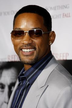 a man wearing sunglasses and smiling at the camera