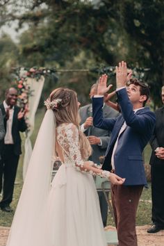 a young boy and girl are standing in front of an outdoor ceremony with their hands up