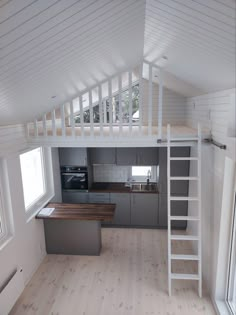 an empty loft with stairs leading up to the kitchen