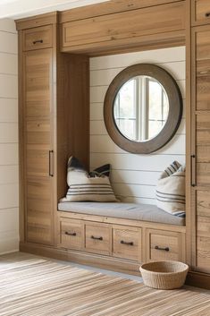 a room with some drawers and a round mirror on the wall next to a window