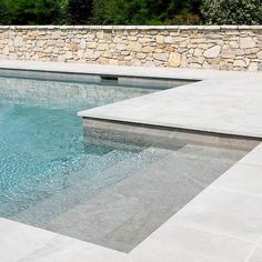 an empty swimming pool surrounded by stone walls