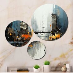 three circular mirrors hanging on the wall next to a vase with plants and books in it