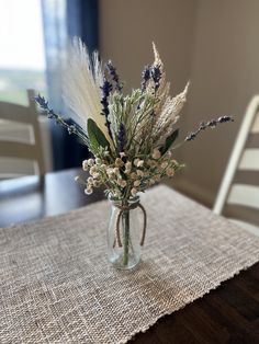 a vase filled with flowers sitting on top of a table covered in burlock