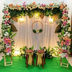 an arrangement of flowers and greenery decorates the backdrop for a wedding ceremony or reception