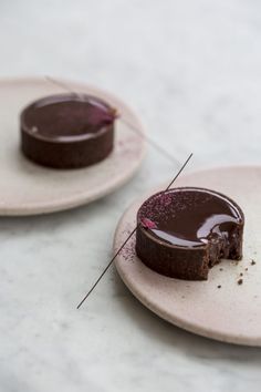 two plates with one piece of chocolate cake on it