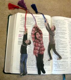 an open book with two people holding up tassels on top of each other