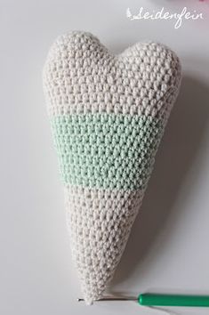 a crocheted heart sitting on top of a table next to a green marker