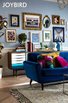 a living room with blue couches and pictures on the wall above them, along with other furniture