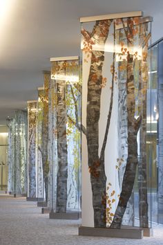 an office lobby with glass walls and trees painted on the wall