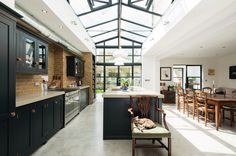 an open kitchen and dining room area with skylights above the countertop, along with a dog laying on the chair