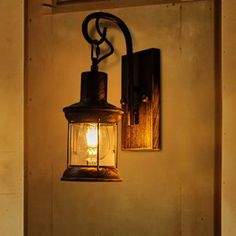 an old fashioned light hanging from the side of a wall next to a lamp fixture