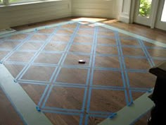 an empty room with blue tape on the floor