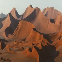 the desert is covered in sand dunes and mountains, with sparse trees on each side