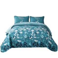 a bed with blue comforters and pillows on top of it, in front of a white background