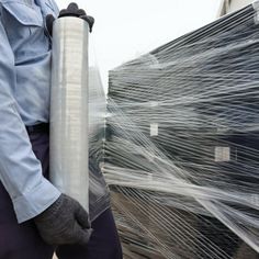 a man holding a roll of plastic wrap