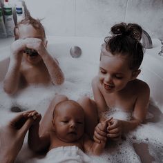 two young children are playing in the bathtub