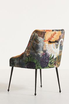 an upholstered chair with flowers and birds on it