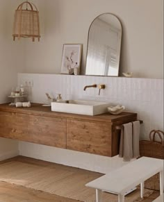 a bathroom with a sink, mirror and wooden cabinet in it's center area