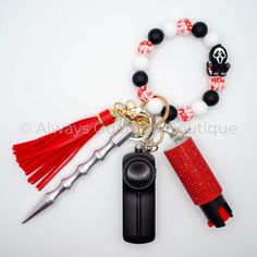 a red and white beaded key chain with some charms attached to it, along with a pair of scissors