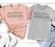 two t - shirts with the words proud to grandma and grandpa printed on them next to shoes