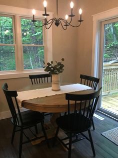 a dining room table with four chairs and a potted plant on top of it