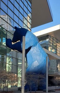 a large blue bear statue in front of a building