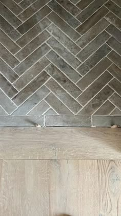 a bathroom with wood floors and tile on the floor, next to a toilet paper dispenser