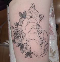 a woman with a tattoo on her arm has a cat and flowers around her leg