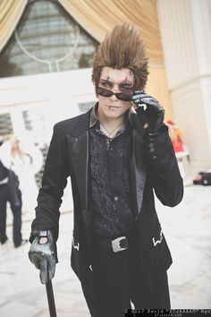 a young man dressed in black holding an umbrella