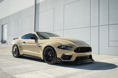 a tan mustang parked in front of a building