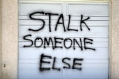 graffiti written on the side of a garage door reads,'talk someone else '