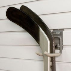 a close up of a metal door handle on a white wall with a black board attached to it