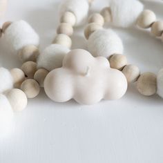 a close up of a necklace made out of wood beads and white cotton ball beads