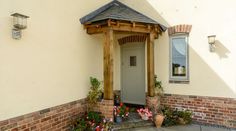 the front entrance to a house with potted plants