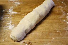 a long piece of bread sitting on top of a wooden table