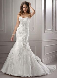 a woman in a white wedding dress posing for the camera with her hand on her head