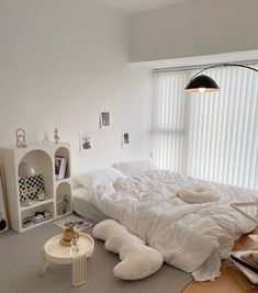 a white bed sitting in a bedroom next to a window